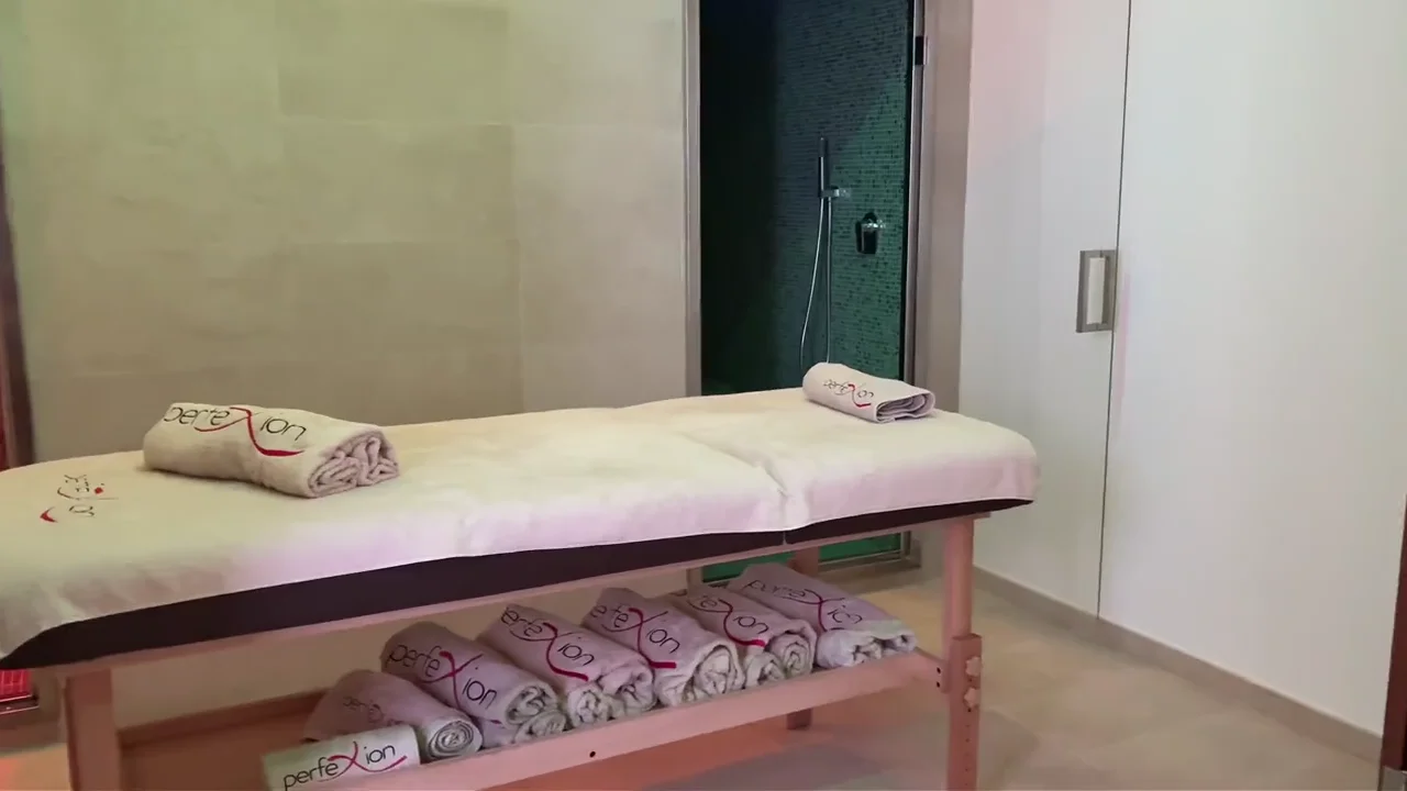 Sala trattamenti di Perfexion Spa con lettini e asciugamani